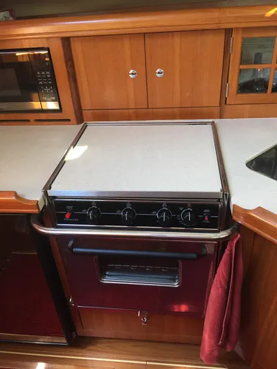 Sapphire Yacht Photos Pics 2007 Hunter 41 Deck Salon kitchen with stove, microwave, and wooden cabinetry.