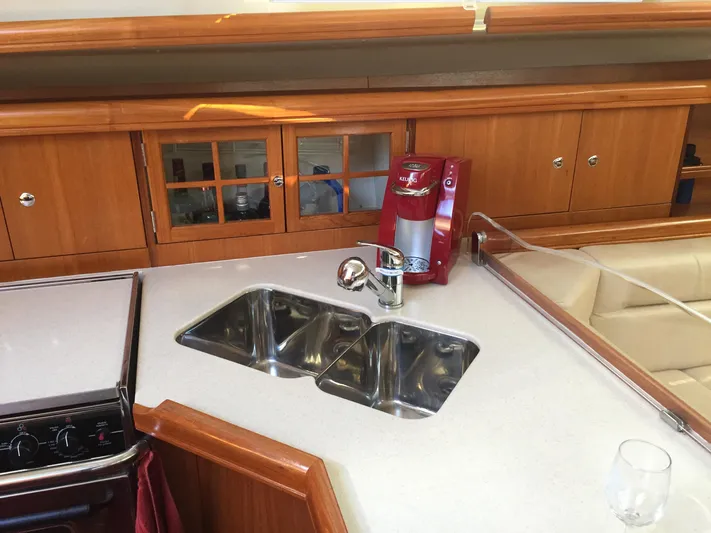 Sapphire Yacht Photos Pics 2007 Hunter 41 Deck Salon kitchen with dual sinks, red coffee maker, and wooden cabinetry.