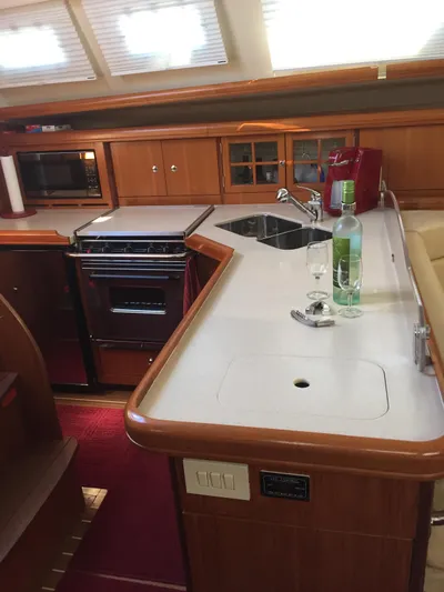 Sapphire Yacht Photos Pics 2007 Hunter 41 Deck Salon interior kitchen with stove, sink, and wine bottle.