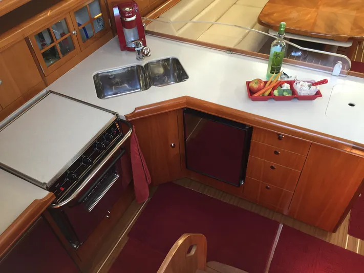 Sapphire Yacht Photos Pics 2007 Hunter 41 Deck Salon kitchen with stove, sink, and countertop featuring fruit and wine.