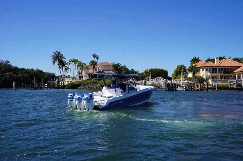  Yacht Photos Pics 2023 Nor-Tech 340 Sport Open Center Console boat cruising near waterfront homes.