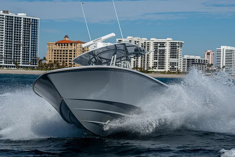  Yacht Photos Pics 2022 Contender 39 ST boat cruising on water with city skyline in background.