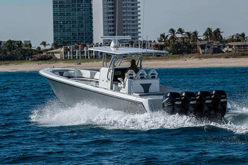  Yacht Photos Pics 2022 Contender 39 ST boat cruising on ocean near city shoreline.