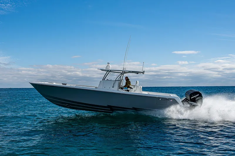  Yacht Photos Pics 2022 Contender 39 ST boat cruising on open water under a clear blue sky.