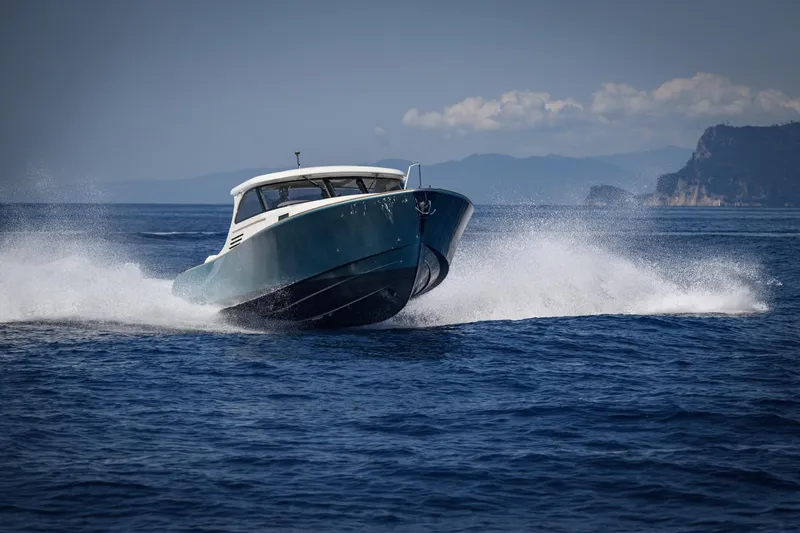 39 Outboard Yacht Photos Pics 2025 Toy 39 Outboard boat speeding on open water with scenic coastline.