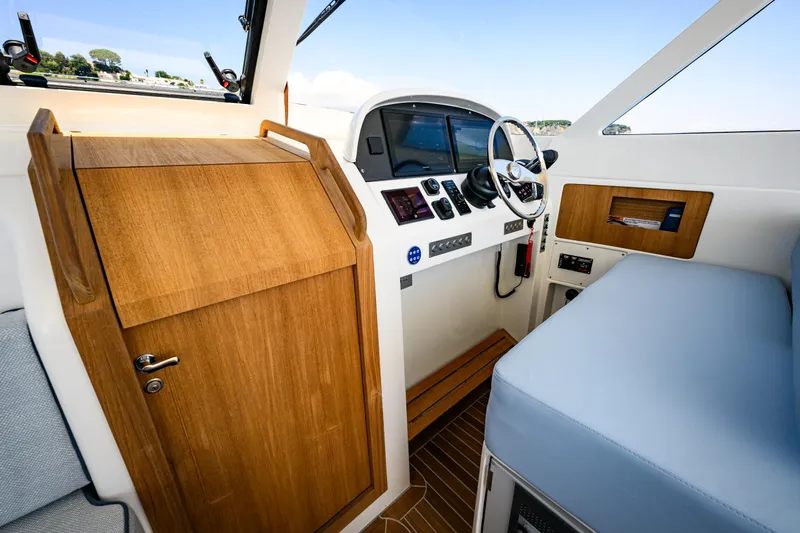 39 Outboard Yacht Photos Pics Interior of 2025 Toy 39 outboard boat with wooden cabinetry and modern controls.