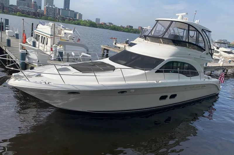  Yacht Photos Pics 2007 Sea Ray 520 Sedan Bridge yacht docked in a marina with city skyline.