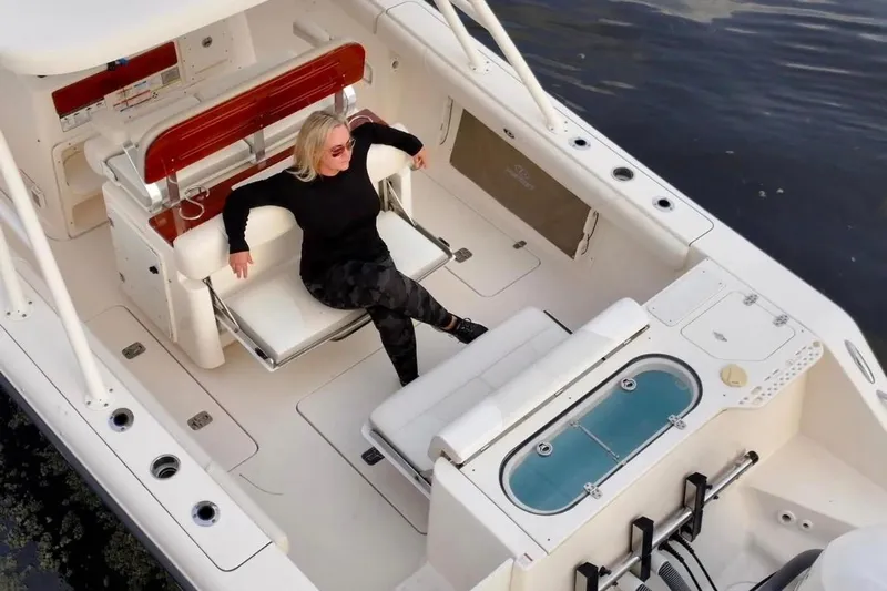  Yacht Photos Pics Woman relaxing on a 2014 Pursuit S 280 Sport boat, enjoying the open deck.