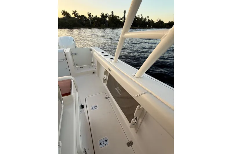  Yacht Photos Pics 2014 Pursuit S 280 Sport boat interior, featuring spacious deck and storage, near water at sunset.