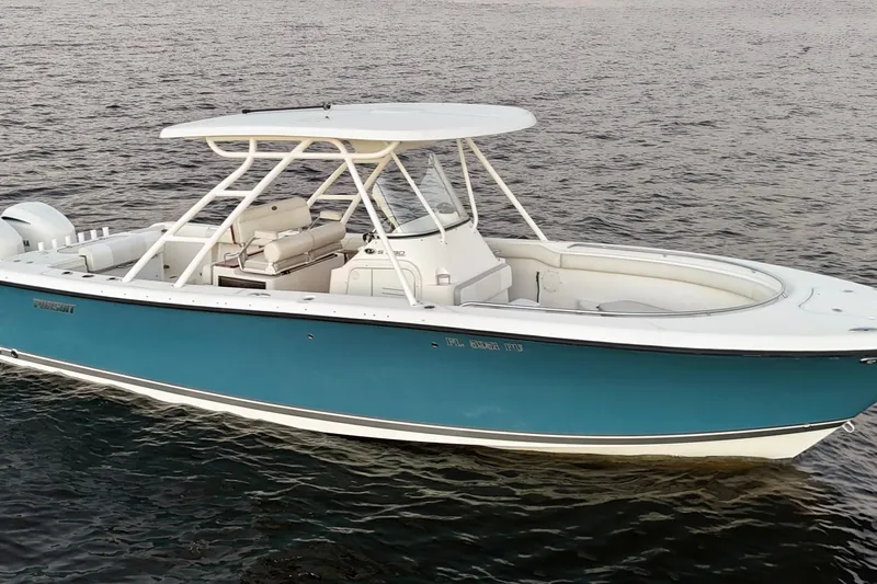  Yacht Photos Pics 2014 Pursuit S 280 Sport boat on calm water, featuring sleek design and blue hull.