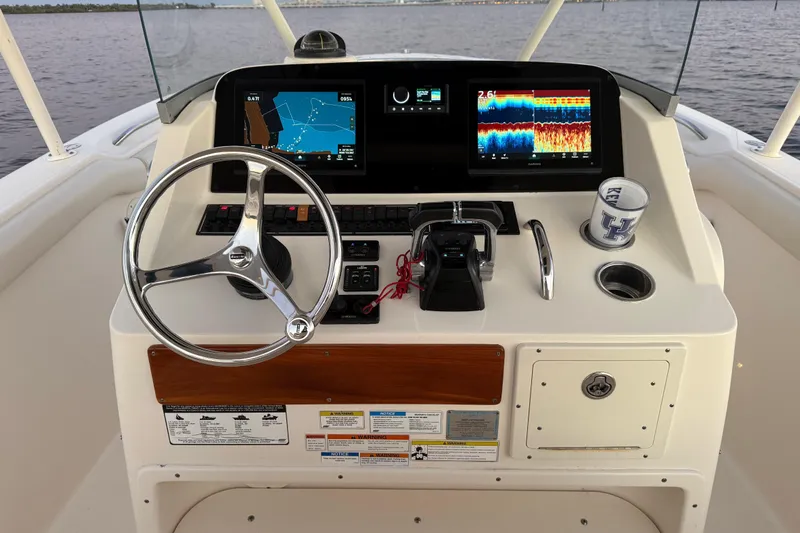  Yacht Photos Pics 2014 Pursuit S 280 Sport boat dashboard with navigation screens and steering wheel.