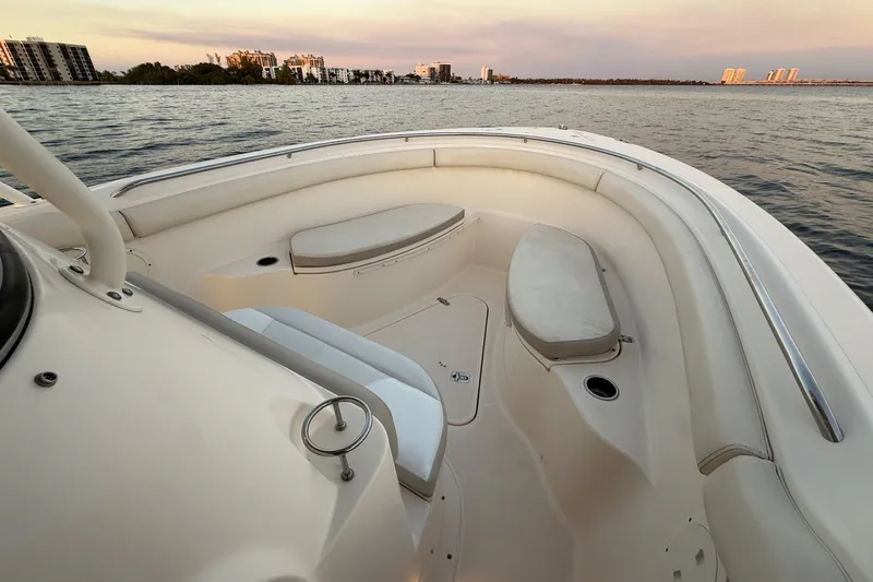  Yacht Photos Pics 2014 Pursuit S 280 Sport boat interior with cushioned seating, on calm water at sunset.