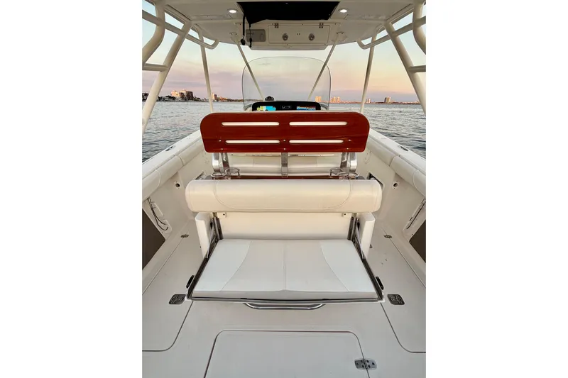  Yacht Photos Pics 2014 Pursuit S 280 Sport boat interior with seating, overlooking calm waters at sunset.