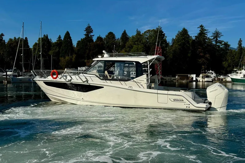 Days Ahead Yacht Photos Pics 2022 Boston Whaler 405 Conquest cruising in a scenic marina setting.
