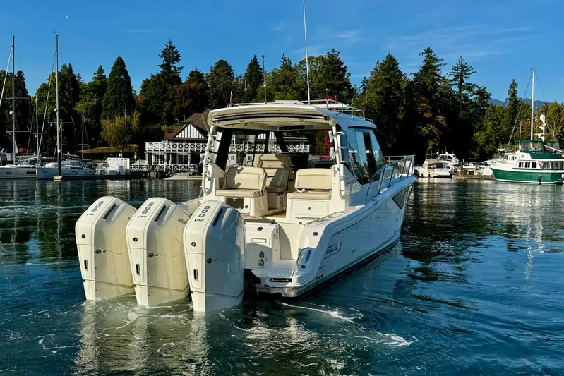 Days Ahead Yacht Photos Pics 2022 Boston Whaler 405 Conquest boat with triple engines in a scenic marina.