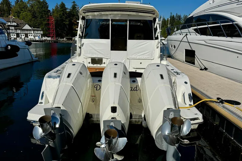 Days Ahead Yacht Photos Pics 2022 Boston Whaler 405 Conquest with triple outboard engines docked at marina.