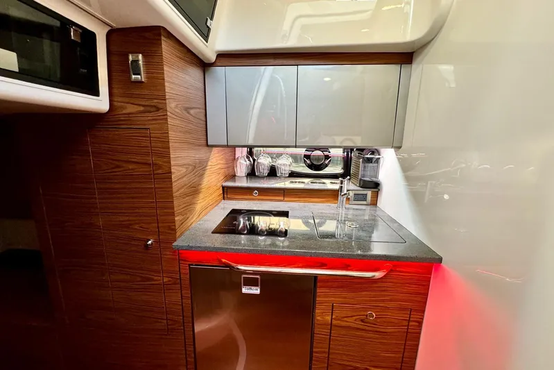 Days Ahead Yacht Photos Pics Modern kitchen area in 2022 Boston Whaler 405 Conquest boat, featuring sleek cabinetry and appliances.
