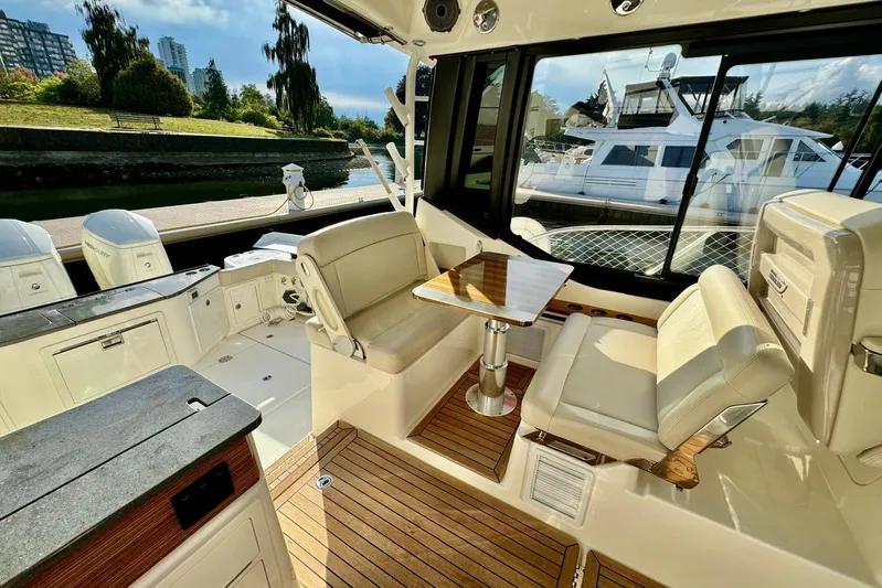 Days Ahead Yacht Photos Pics 2022 Boston Whaler 405 Conquest interior with seating and table, docked near luxury yachts.