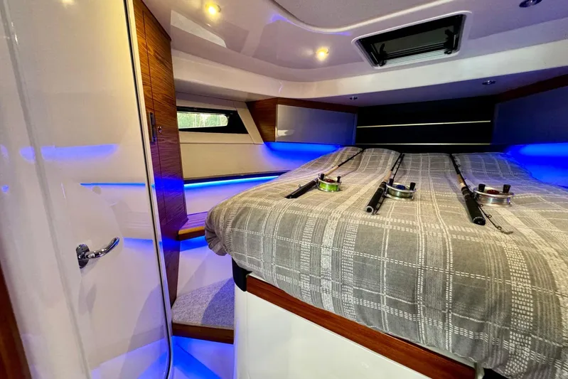 Days Ahead Yacht Photos Pics Luxurious cabin interior of 2022 Boston Whaler 405 Conquest with fishing rods and ambient lighting.