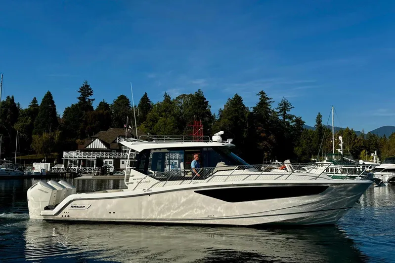 Days Ahead Yacht Photos Pics 2022 Boston Whaler 405 Conquest boat on calm water near a marina.