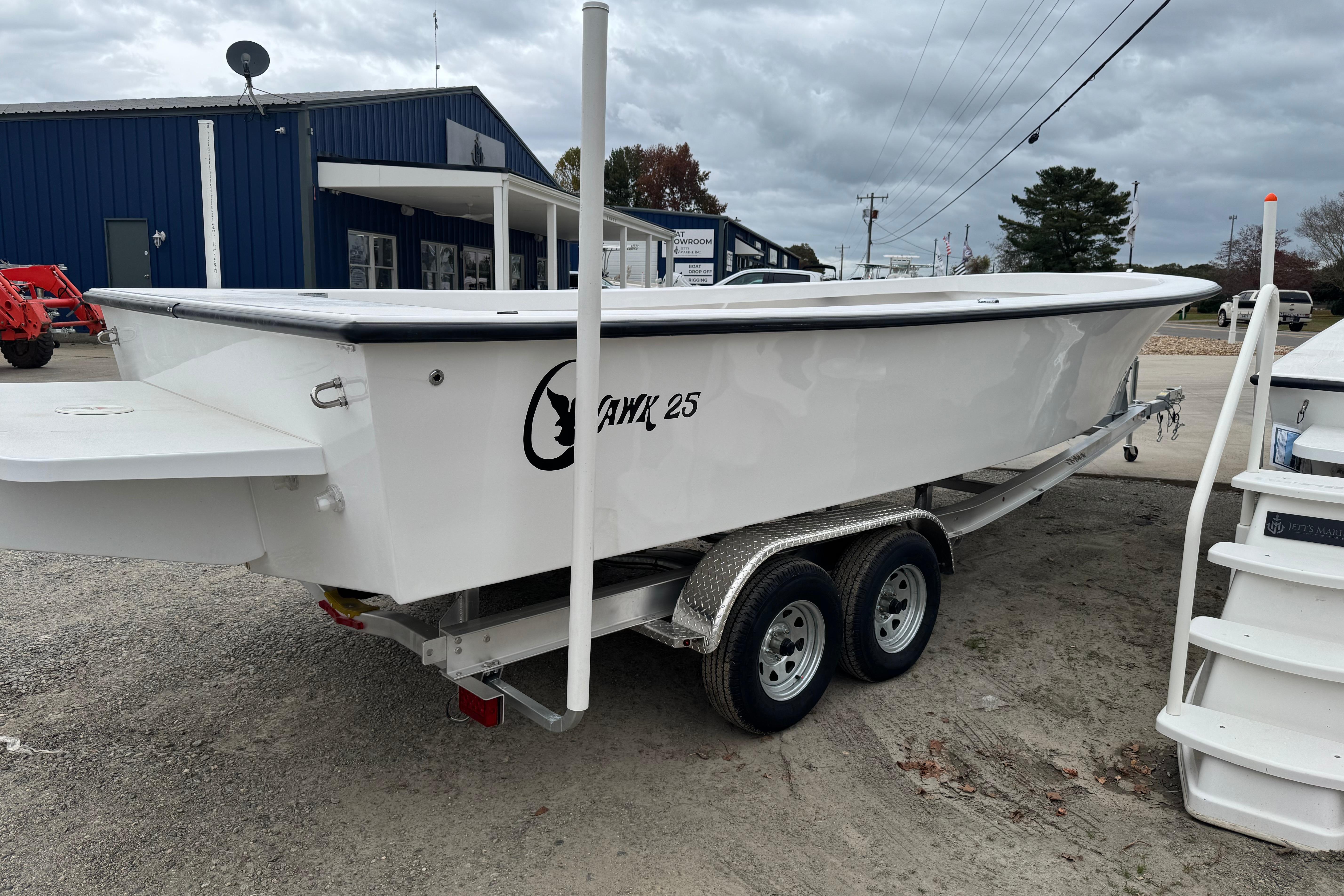2026 C-Hawk 26 Center Console boat on trailer, parked outdoors near a blue building.