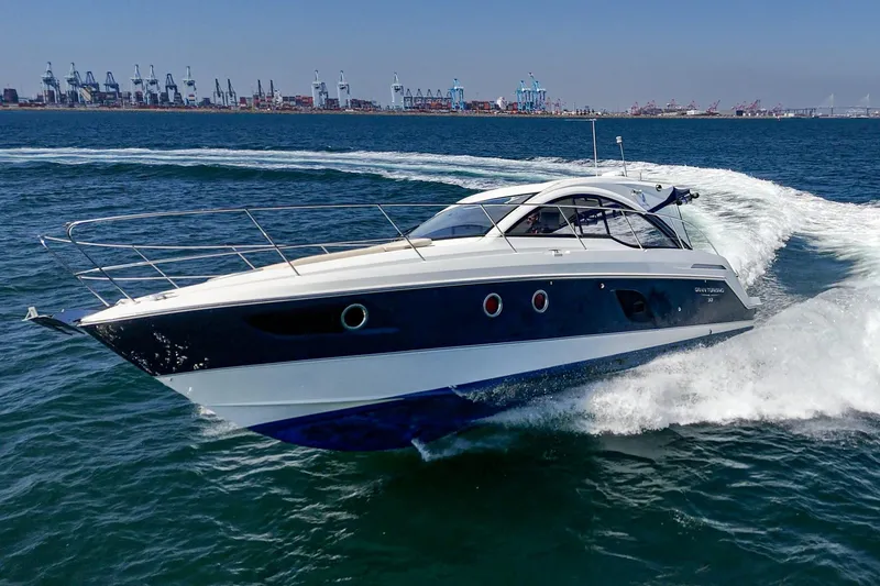  Yacht Photos Pics 2014 Beneteau Gran Turismo 38 yacht cruising on open water near industrial port.