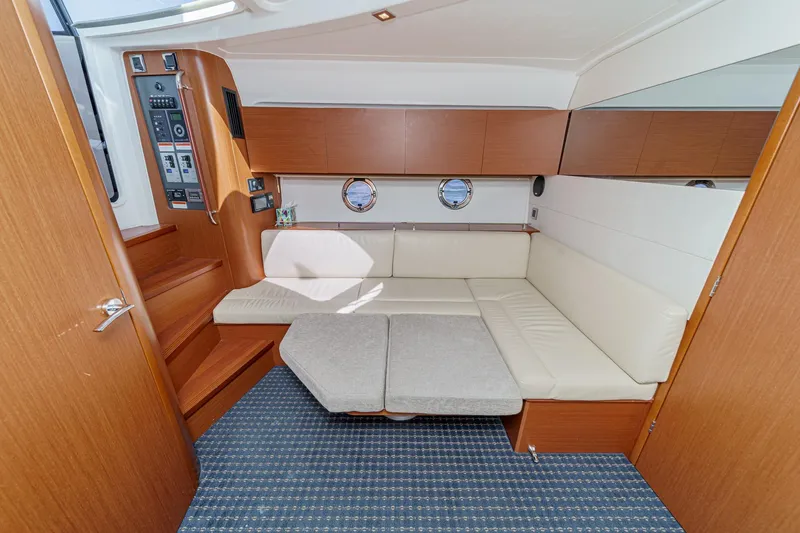  Yacht Photos Pics Interior of 2014 Beneteau Gran Turismo 38 yacht with beige seating and wooden cabinetry.