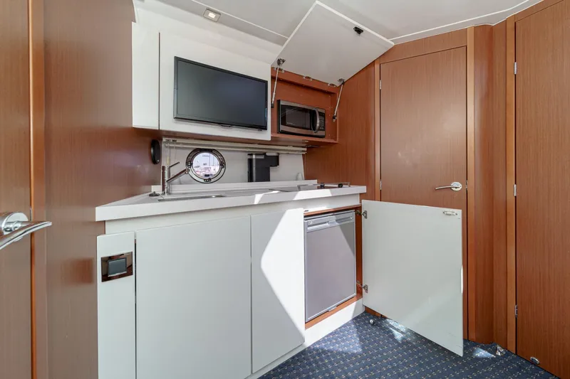  Yacht Photos Pics 2014 Beneteau Gran Turismo 38 yacht interior with kitchenette, featuring microwave and TV.
