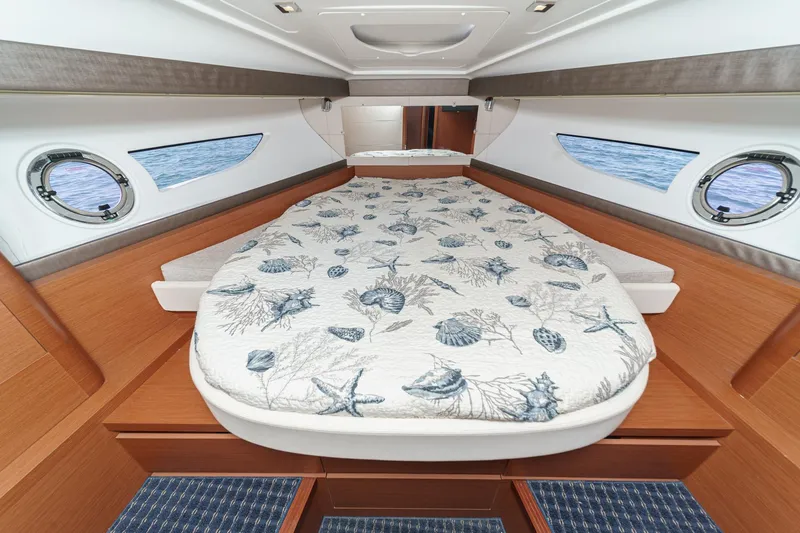  Yacht Photos Pics Luxurious cabin interior of 2014 Beneteau Gran Turismo 38 yacht with nautical-themed bedding.
