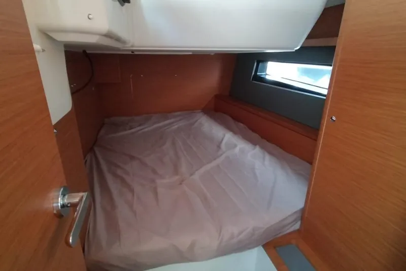  Yacht Photos Pics 2024 Dufour 44 yacht cabin interior with wooden finish and cozy bed.