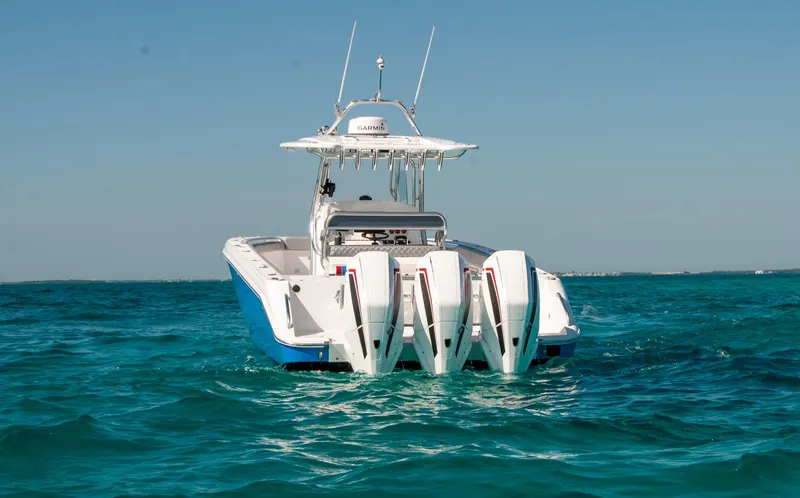  Yacht Photos Pics A sleek IMG 40 boat with triple engines cruising on clear blue water.