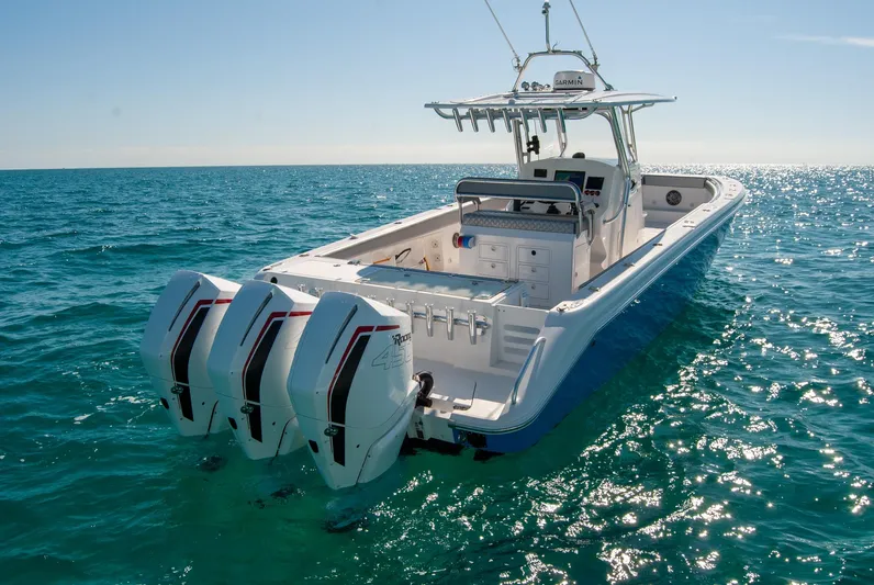  Yacht Photos Pics A sleek IMG 40 boat with triple engines cruising on clear blue ocean waters.