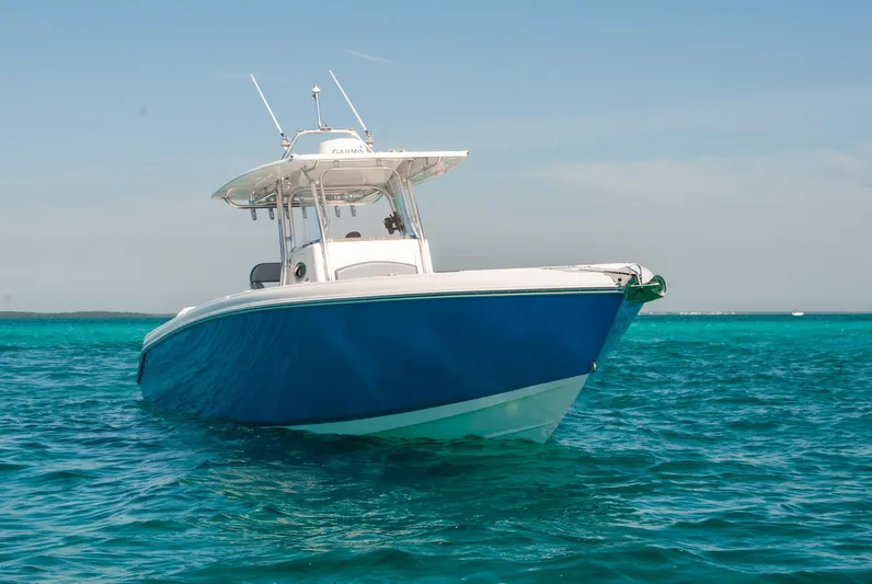  Yacht Photos Pics Blue and white boat on clear turquoise water under a sunny sky.
