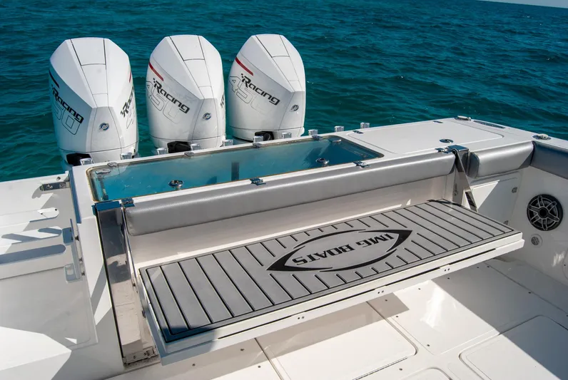  Yacht Photos Pics Triple outboard motors on a sleek boat deck, IMG 40 model, 2021, cruising on blue ocean waters.