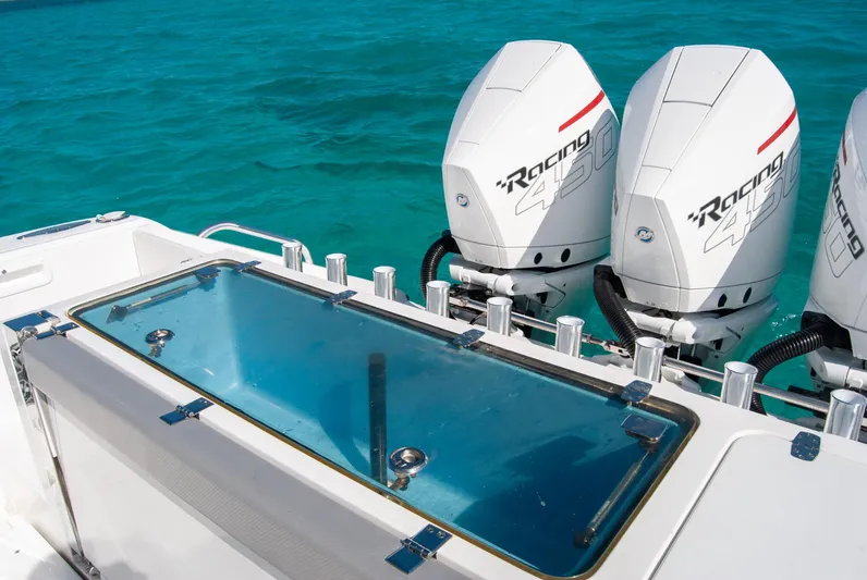  Yacht Photos Pics Boat with twin outboard engines on clear turquoise water.