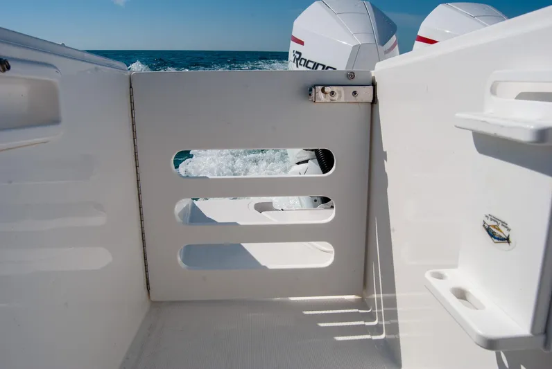  Yacht Photos Pics Boat deck with open gate, ocean view, and powerful outboard engines in the background.