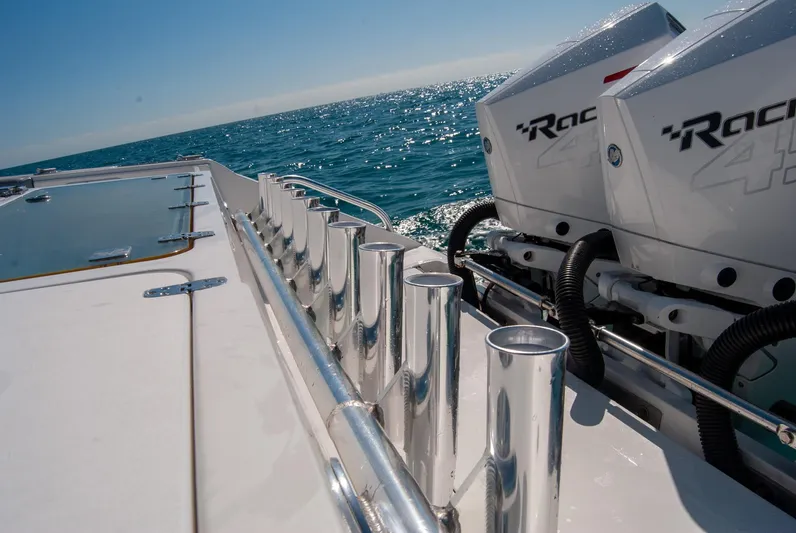  Yacht Photos Pics Boat deck with rod holders and powerful engines on a sunny day at sea.