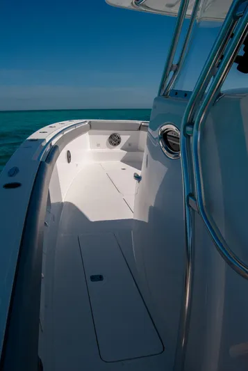  Yacht Photos Pics Sleek white boat deck with stainless steel railings under clear blue sky.