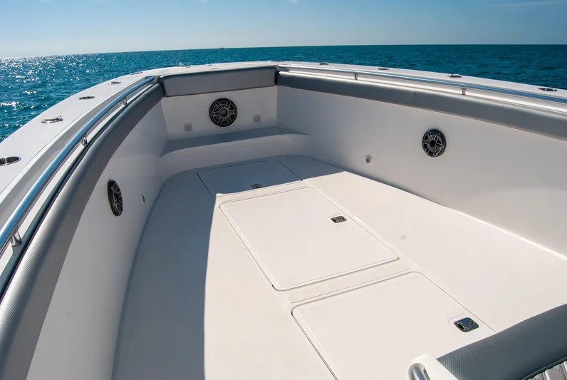  Yacht Photos Pics Spacious boat deck with storage compartments, surrounded by ocean, under clear blue sky.