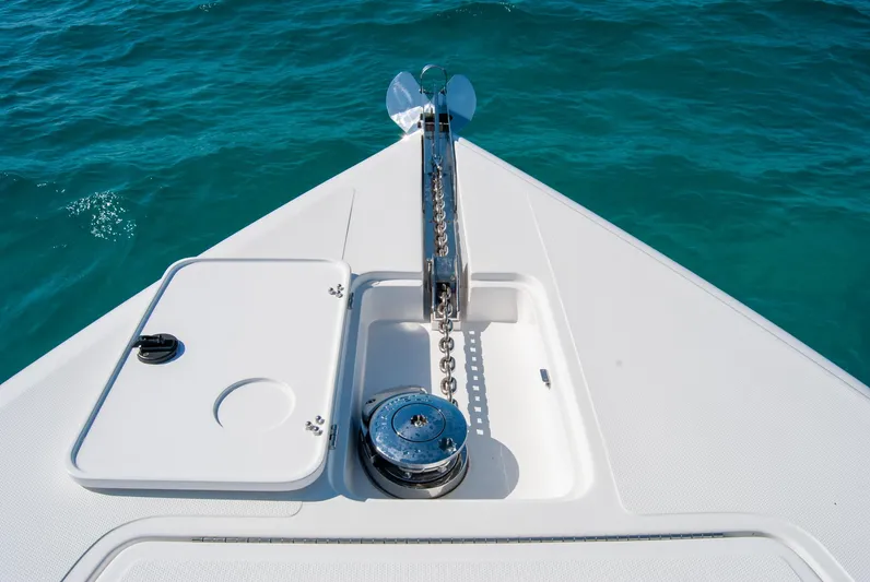  Yacht Photos Pics Bow of a boat with anchor chain mechanism on turquoise water.