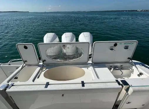  Yacht Photos Pics Boat deck with storage compartments and three outboard motors on a sunny day.