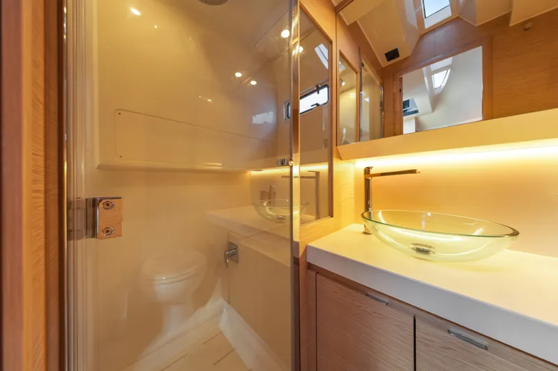  Yacht Photos Pics Luxurious bathroom interior of 2024 Solaris Power 44 yacht with glass sink and modern fixtures.