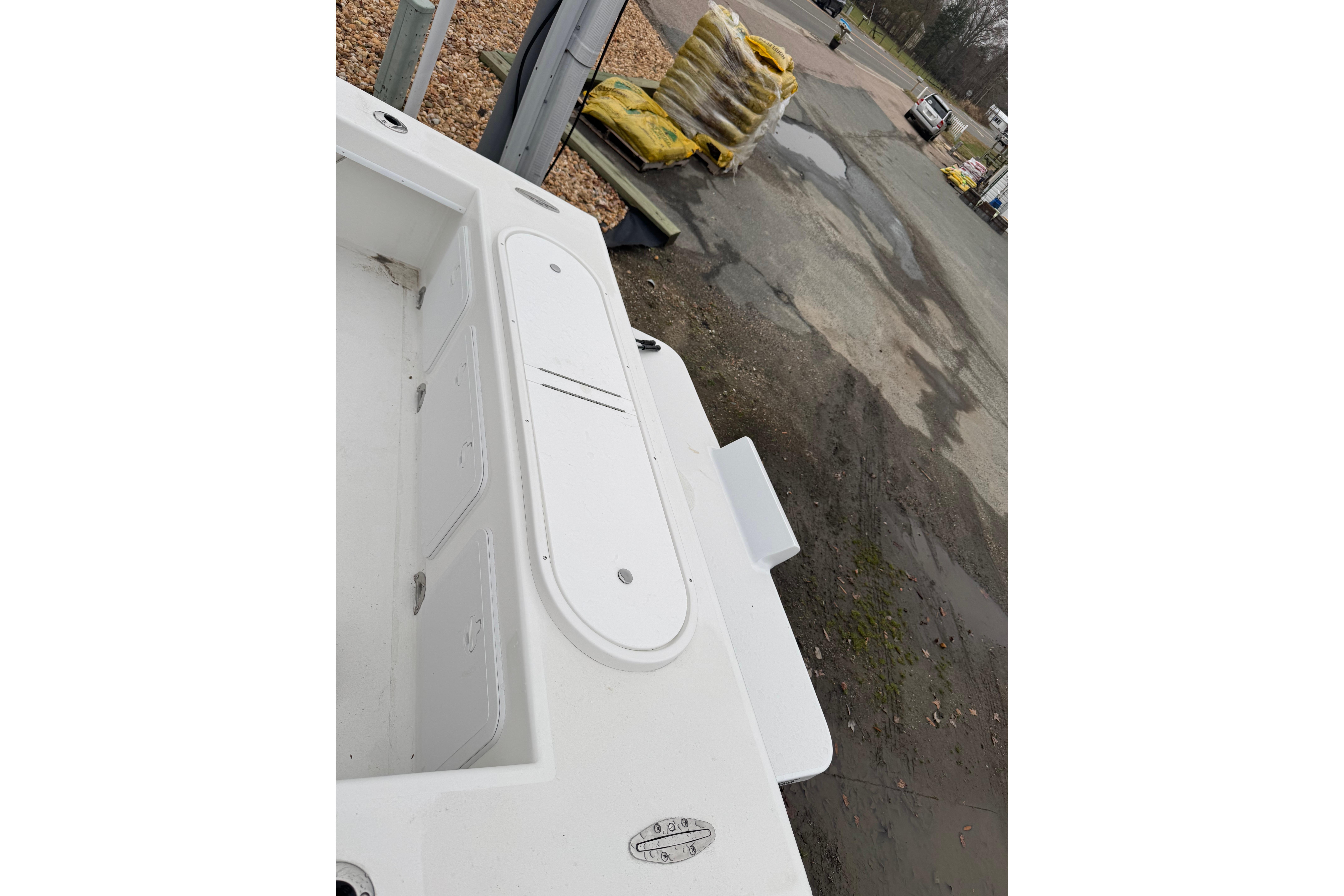 2026 C-Hawk 23 Center Console boat deck with storage compartments, parked outdoors.