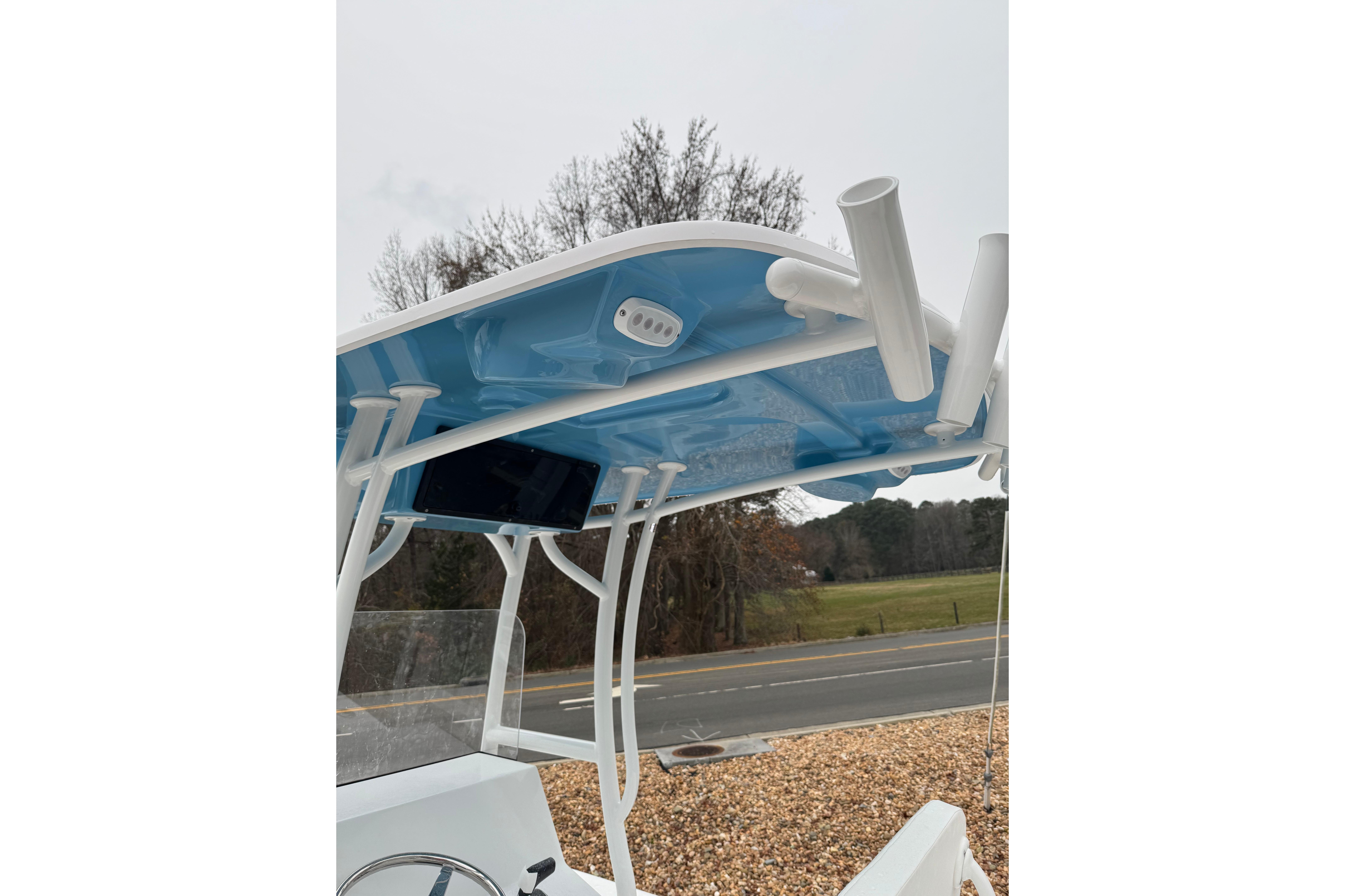 2026 C-Hawk 23 Center Console boat with blue T-top and rod holders.