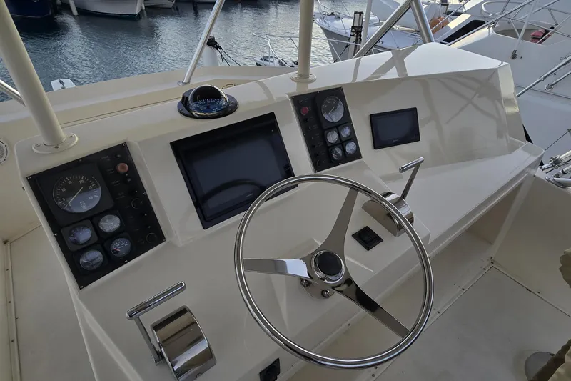  Yacht Photos Pics 1990 Viking 43 Convertible yacht helm with steering wheel and navigation instruments.