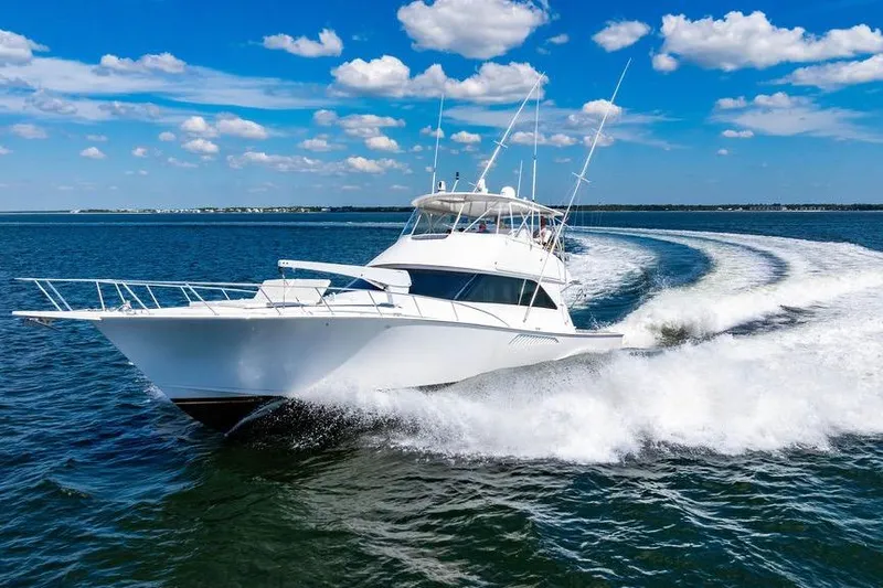 Reel Southern Yacht Photos Pics 2006 Viking 56 Convertible yacht cruising on open water under a clear blue sky.