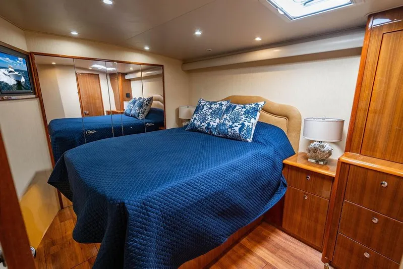Reel Southern Yacht Photos Pics Luxurious bedroom interior of 2006 Viking 56 Convertible yacht with blue bedding and wooden furnishings.
