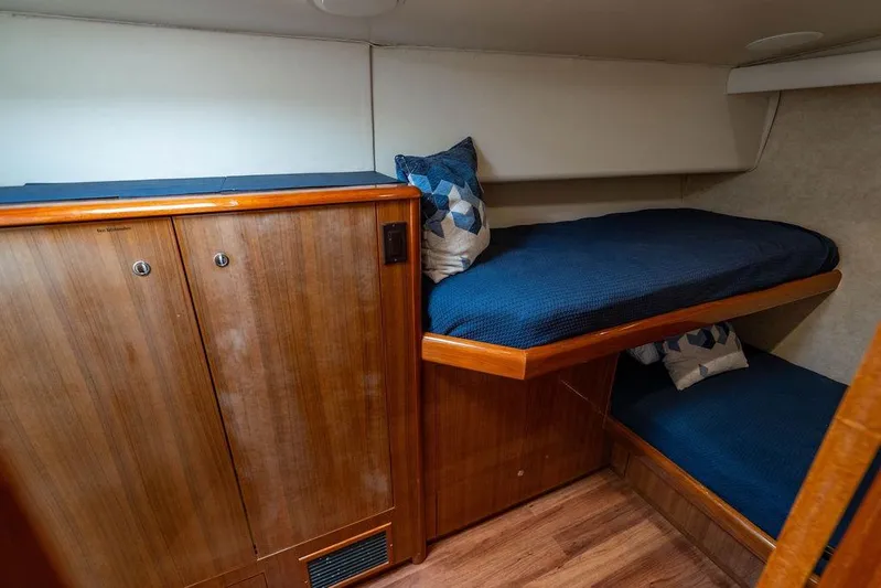 Reel Southern Yacht Photos Pics 2006 Viking 56 Convertible yacht cabin with wooden cabinetry and blue bedding.