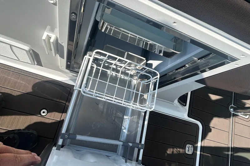  Yacht Photos Pics Open storage compartment on 2019 Cobalt R30 boat, featuring a pull-out wire basket.