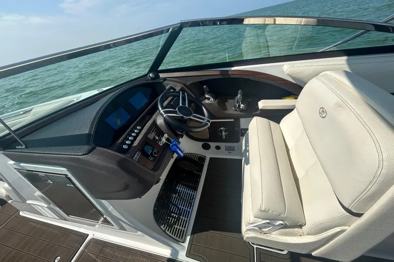  Yacht Photos Pics 2019 Cobalt R30 boat cockpit with steering wheel and white seating on open water.